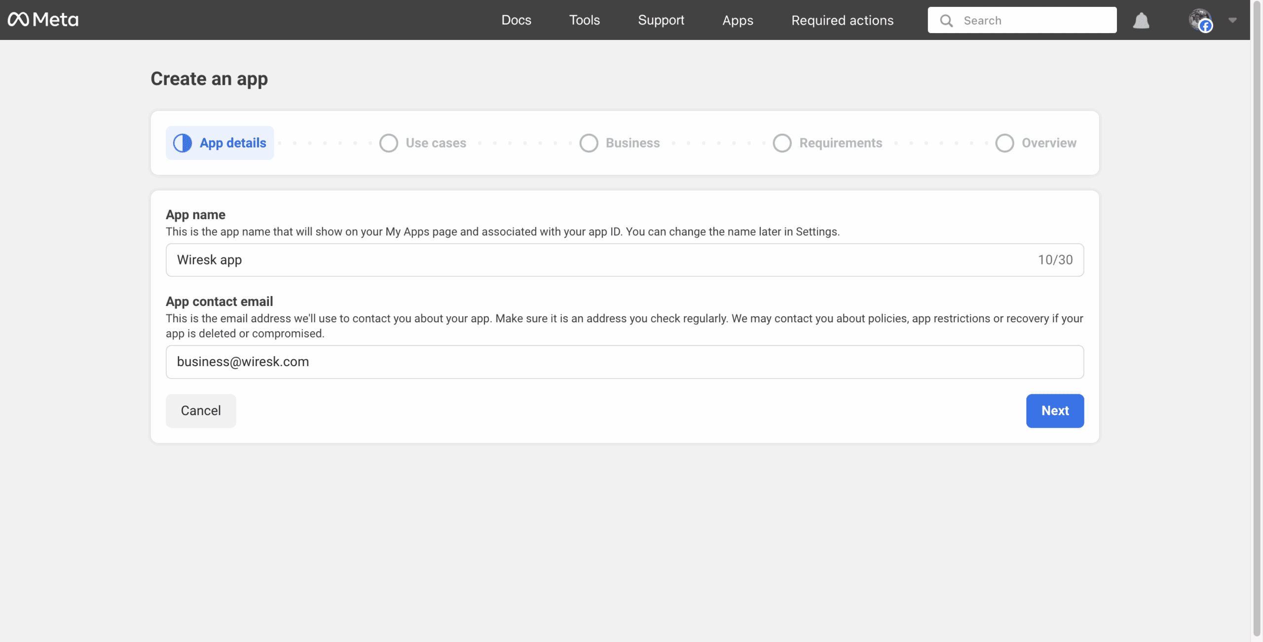 Meta Developer portal screen for creating a new app. The "App details" step is selected in the progress bar. The form includes two fields: "App name" with the value "Wiresk app" and "App contact email" with the value "business@wiresk.com". Below the form are "Cancel" and "Next" buttons. The screen guides the user through the process of registering a new app for Meta services.